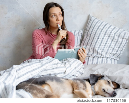 woman in bed writes in personal diary, writes down emotions, writes down wish list. mental health. woman in bed writes in personal diary, writes down emotions, writes down wish list. mental health. 137830366