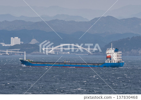 Ocean cargo ship sailing across the cloudy sea Ocean cargo ship sailing across the cloudy sea 137830468