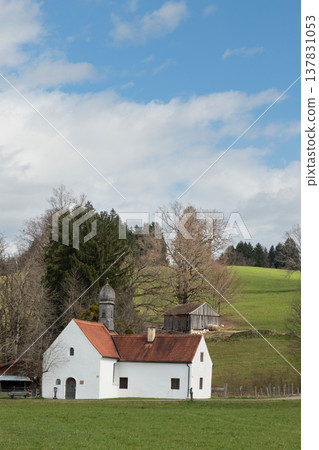 Small white rural chapel on green hillside in Bavarian countryside Germany 137831053