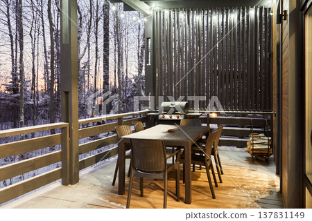 Tranquil rustic porch illuminated warmly for nighttime dining Tranquil rustic porch illuminated warmly for nighttime dining 137831149