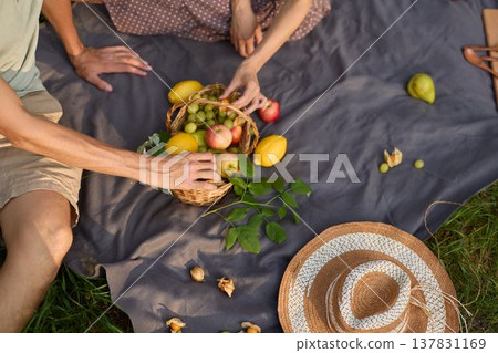 Sunshine illuminates couple enjoying fresh fruits together outdoors Sunshine illuminates couple enjoying fresh fruits together outdoors 137831169