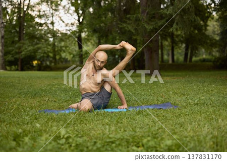 Serene individual performing seated flow in peaceful park environment 137831170