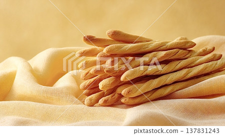 Italian grissini breadsticks resting on yellow rustic fabric Italian grissini breadsticks resting on yellow rustic fabric 137831243