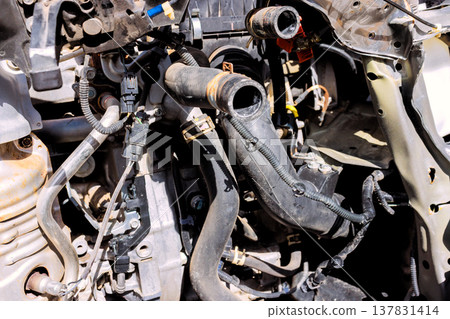 Engine components shown with hoses wires at car during repair in an auto garage Engine components shown with hoses wires at car during repair in an auto garage 137831414