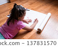 Young asian girl drawing on white paper with pencils on wooden floor 137831570