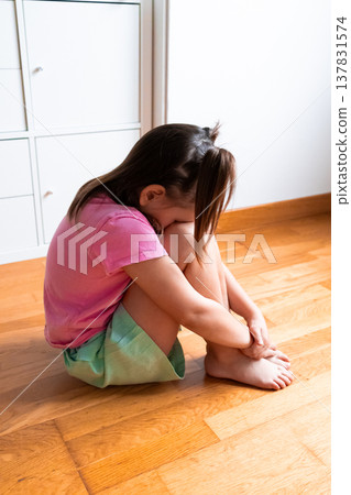 Young caucasian female child sitting cross legged in a room 137831574