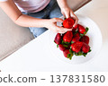 Female child enjoying fresh strawberries from a bowl 137831580