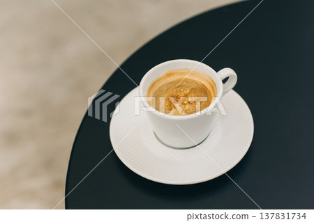 Cup of black coffee on a table in a street cafe. Cup of black coffee on a table in a street cafe. 137831734