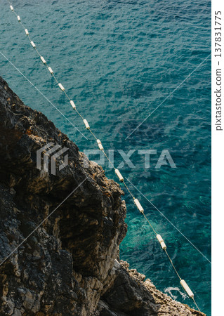 Rocks and buoys in the turquoise sea water. Rocks and buoys in the turquoise sea water. 137831775
