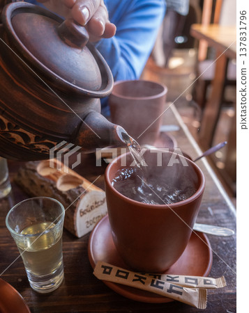 [Ukraine] A scene of tea being poured into a cup from a ceramic teapot at a restaurant in Lviv, western Ukraine. 137831796