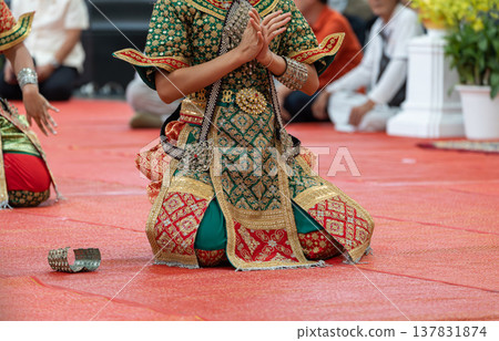 Traditional Thai dance close perspective focusing on expressive hand and foot gestures with intricate costume details and cultural performance style. Traditional Thai dance close perspective focusing on expressive hand and foot gestures with intricate costume details and cultural performance style. 137831874