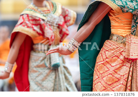 Traditional Thai dance close perspective focusing on expressive hand and foot gestures with intricate costume details and cultural performance style. Traditional Thai dance close perspective focusing on expressive hand and foot gestures with intricate costume details and cultural performance style. 137831876