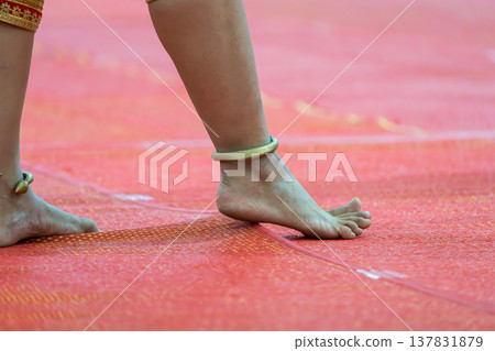 Traditional Thai dance close perspective focusing on expressive hand and foot gestures with intricate costume details and cultural performance style. Traditional Thai dance close perspective focusing on expressive hand and foot gestures with intricate costume details and cultural performance style. 137831879