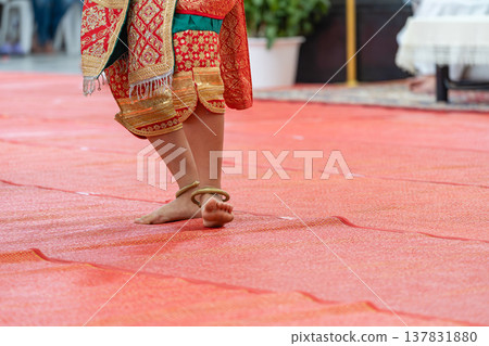 Traditional Thai dance close perspective focusing on expressive hand and foot gestures with intricate costume details and cultural performance style. Traditional Thai dance close perspective focusing on expressive hand and foot gestures with intricate costume details and cultural performance style. 137831880