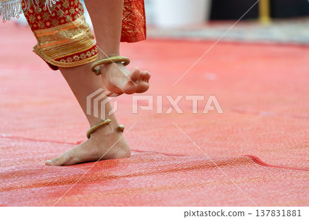 Traditional Thai dance close perspective focusing on expressive hand and foot gestures with intricate costume details and cultural performance style. Traditional Thai dance close perspective focusing on expressive hand and foot gestures with intricate costume details and cultural performance style. 137831881