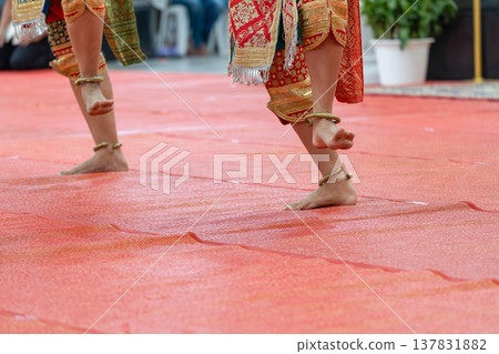 Traditional Thai dance close perspective focusing on expressive hand and foot gestures with intricate costume details and cultural performance style. Traditional Thai dance close perspective focusing on expressive hand and foot gestures with intricate costume details and cultural performance style. 137831882