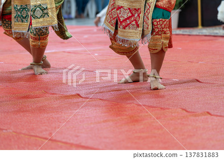 Traditional Thai dance close perspective focusing on expressive hand and foot gestures with intricate costume details and cultural performance style. Traditional Thai dance close perspective focusing on expressive hand and foot gestures with intricate costume details and cultural performance style. 137831883
