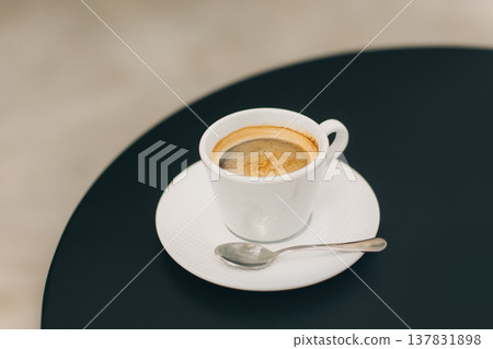 Cup of black coffee on a table in a street cafe. Cup of black coffee on a table in a street cafe. 137831898