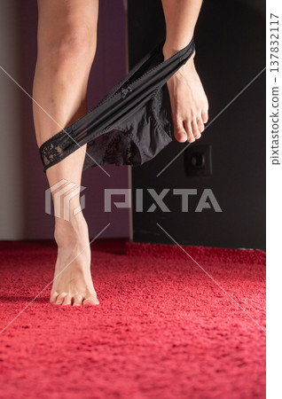 Foot fetish. A woman takes off her black lace panties. Foot fetish. A woman takes off her black lace panties. 137832117