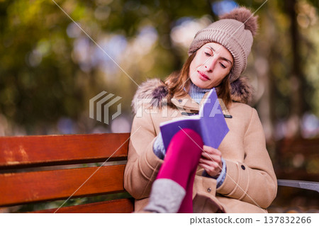 Woman journaling on park bench dealing with eating disorder Woman journaling on park bench dealing with eating disorder 137832266