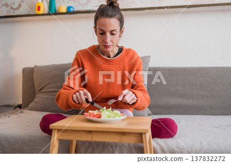 Woman struggling with eating disorder eating healthy salad 137832272