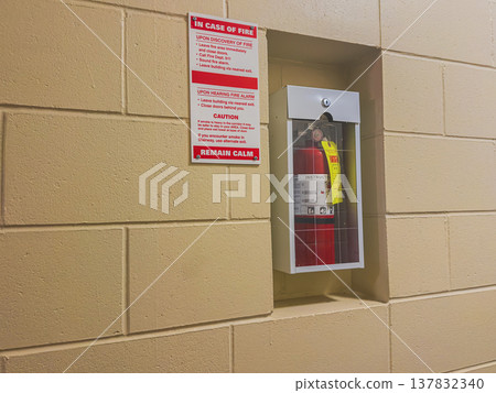 Fire extinguisher and safety sign in hallway 137832340