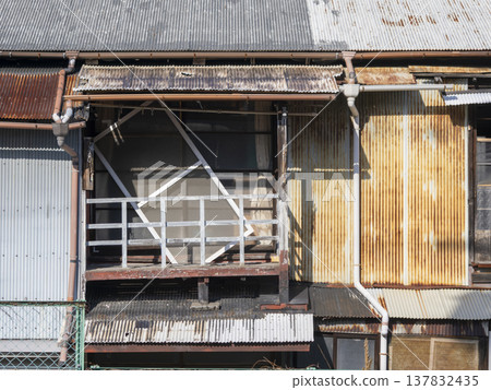 A dilapidated house covered in corrugated iron from the Showa era. A dilapidated house covered in corrugated iron from the Showa era. 137832435