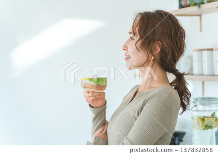 女人在廚房檯面上喝排毒水 137832858