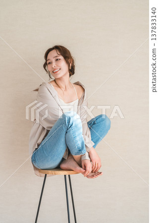 高腳椅,身穿牛仔服的女模特兒坐在椅子上 高腳椅,身穿牛仔服的女模特兒坐在椅子上 137833140