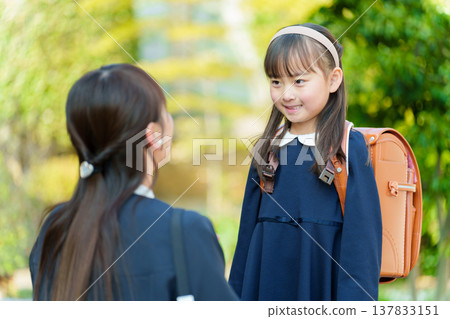 一個女孩和一個媽媽背著書包 一個女孩和一個媽媽背著書包 137833151