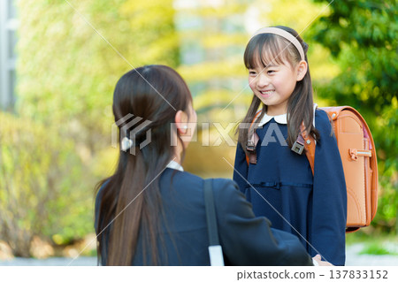 一個女孩和一個媽媽背著書包 137833152