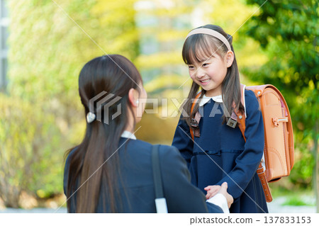 一個女孩和一個媽媽背著書包 137833153