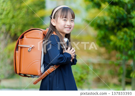 Girls carrying a school bag 137833393