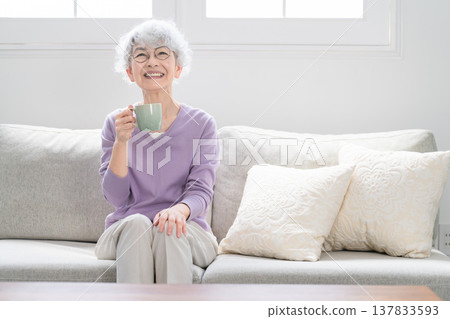 Senior woman relaxing on the sofa drinking coffee 137833593