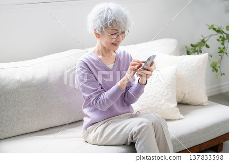 Senior woman operating a smartphone Senior woman operating a smartphone 137833598