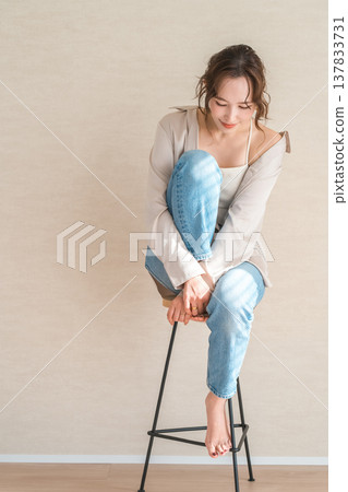 High chair, female model in denim sitting on chair 137833731