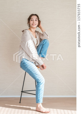 高腳椅，身穿牛仔服的女模特兒坐在椅子上 137833735