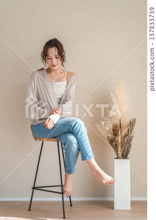 高腳椅，身穿牛仔服的女模特兒坐在椅子上 137833739