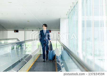 A man carrying a suitcase at the airport 137834594