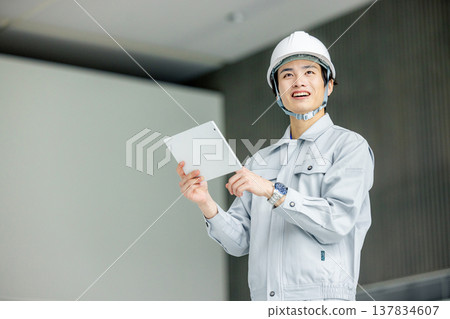 一名男性勞工手持平板電腦 137834607