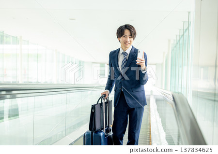 A man carrying a suitcase at the airport A man carrying a suitcase at the airport 137834625