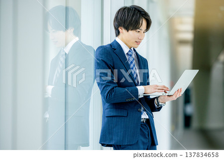 Young businessman with a laptop in the office Young businessman with a laptop in the office 137834658