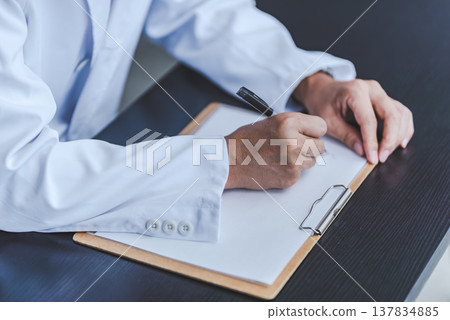 一位身穿白大褂的專家填寫了這些文件。 137834885