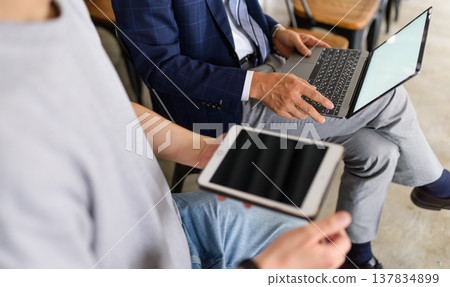 Students with tablets and professors using PCs 137834899