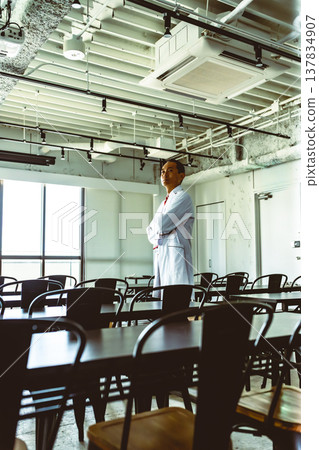 一位中年醫生在實驗室裡雙手交叉抱在胸前。 一位中年醫生在實驗室裡雙手交叉抱在胸前。 137834907