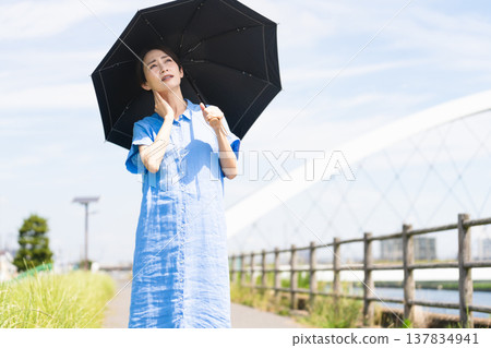 年輕女子打著陽傘散步 — 生活方式形象 年輕女子打著陽傘散步 — 生活方式形象 137834941