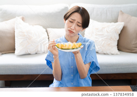 Young woman eating melon lifestyle image Young woman eating melon lifestyle image 137834958