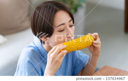 Young woman eating corn lifestyle image Young woman eating corn lifestyle image 137834967