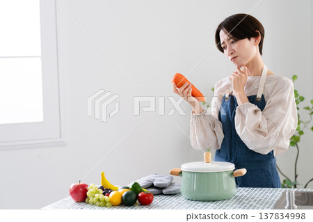 A young woman cooking in an apron Lifestyle image A young woman cooking in an apron Lifestyle image 137834998