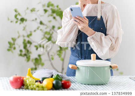 A young woman cooking in an apron Lifestyle image A young woman cooking in an apron Lifestyle image 137834999